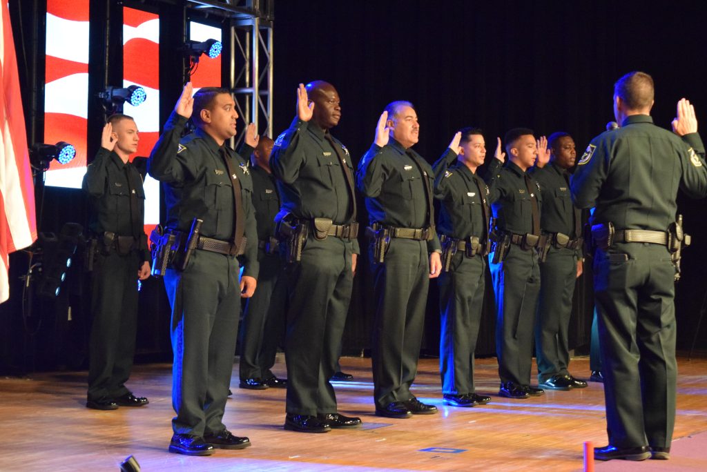 Deputies being sworn in on stage by Sheriff Mina