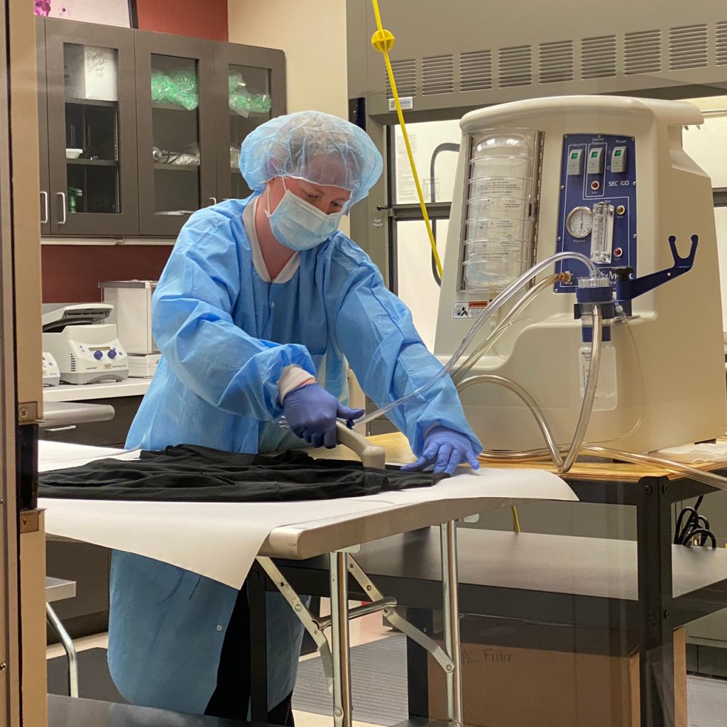 Forensics specialist extracting evidence from a large piece of fabric