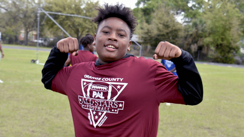 kid flexing on a soccer field