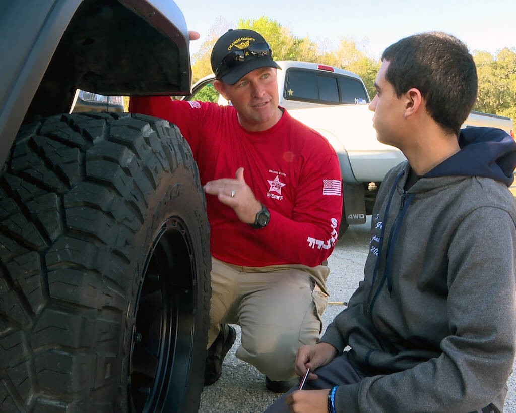 deputy teaching teen to change a tire