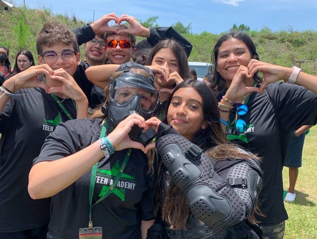 Teen academy class making hand hearts to the camera