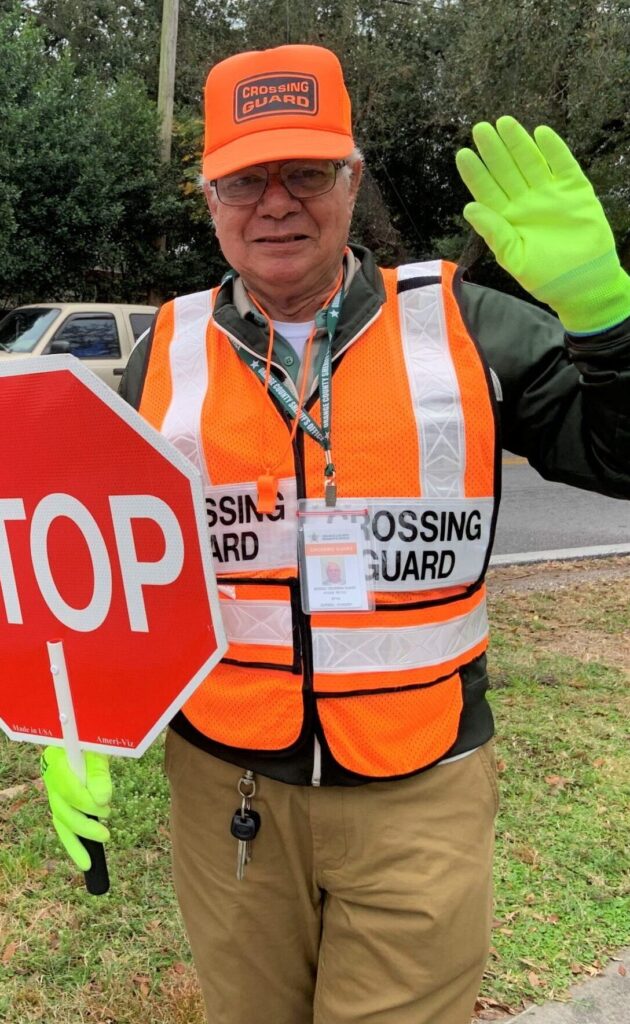a crossing guard waving to the camera